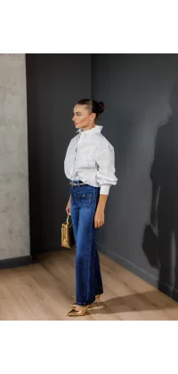 Сині джинси з високою талією та великими передніми кишенями із золотими гудзиками — стильний вибір для повсякденного образу з нотками ретро., одяг від Jador