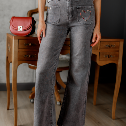 Сірі джинси кльош із м’якого деніму з вишивкою у вигляді сердечка на кишені — ідеальне поєднання зручності та акцентного дизайну.