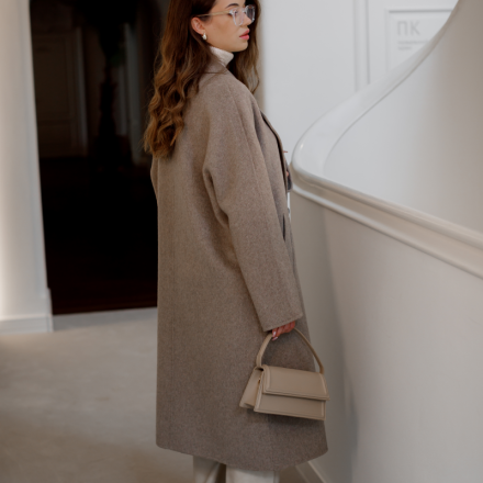 Пальто прямого крою з відкладним коміром та застібкою на гудзики. Відтінок — теплий бежево-сірий (тауп)