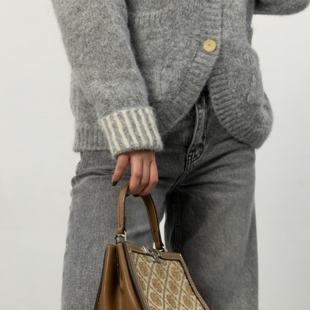 Затишний в'язаний кардиган MiuMiu у світло-сірому кольорі з акцентом на ґудзиках та декоративною брошкою у вигляді квітки.